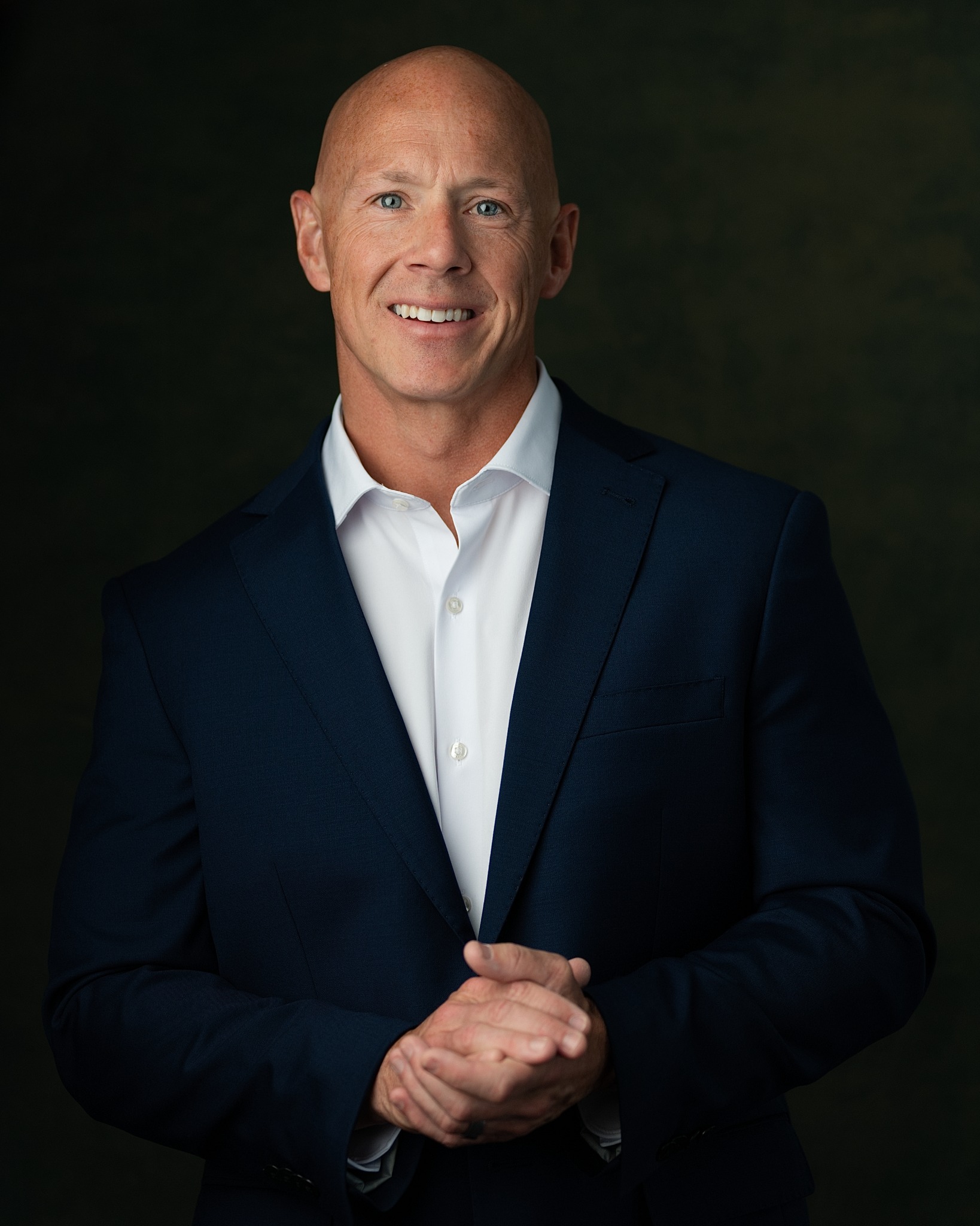 Brian Flanigan smiling in a navy suit